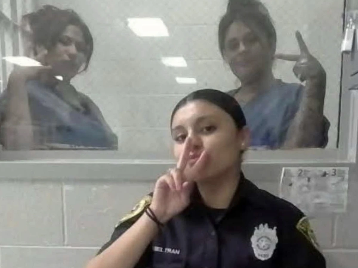 Agente penitenciária posa diante de janela com duas detentas em unidade prisional no Texas.