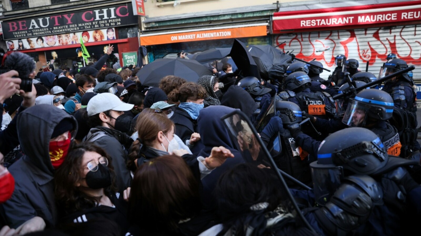 Policiais com escudos diante de manifestantes em uma rua da França