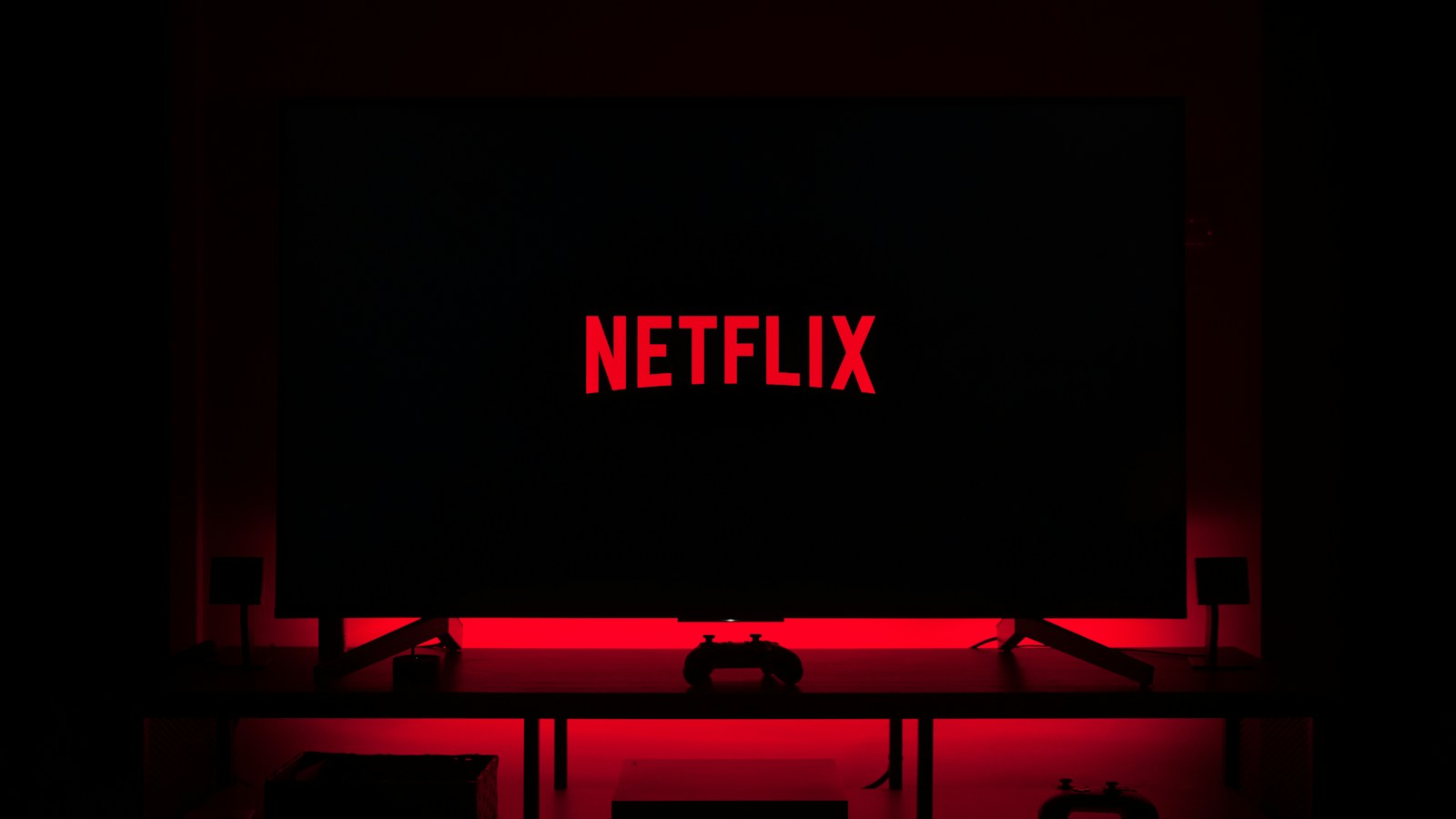 Logotipo da Netflix em uma televisão com iluminação vermelha — foto de arquivo